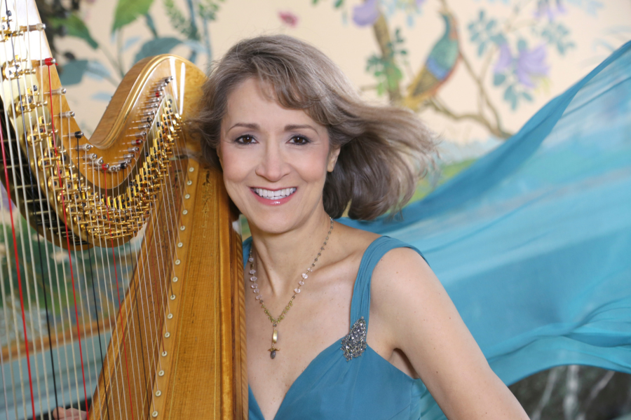 Ann in blue dress Ann Lobotzke sits at her harp wearing a peacock blue dress that billows out behind her.